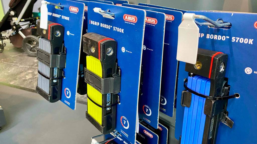 Abus-Faltschloss im Test hängt in seiner blauen Verpackung am Verkaufsstand.