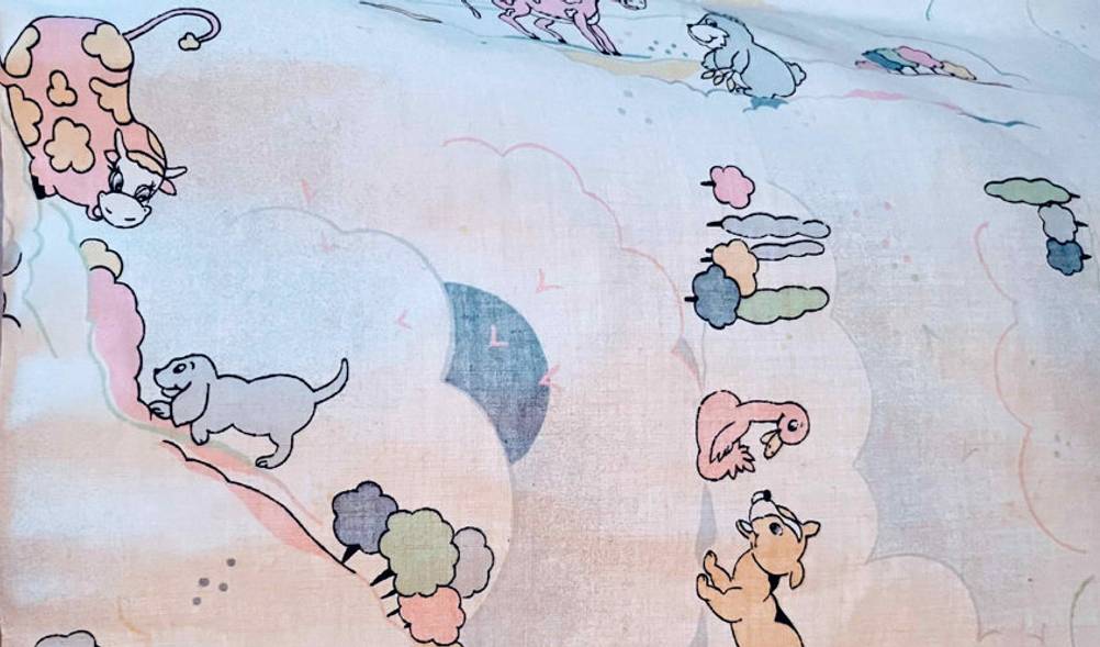 Baby-Reisebett im Test: Detailaufnahme der Stoffverkleidung mit niedlichen Tiermotiven in sanften Farbtönen.