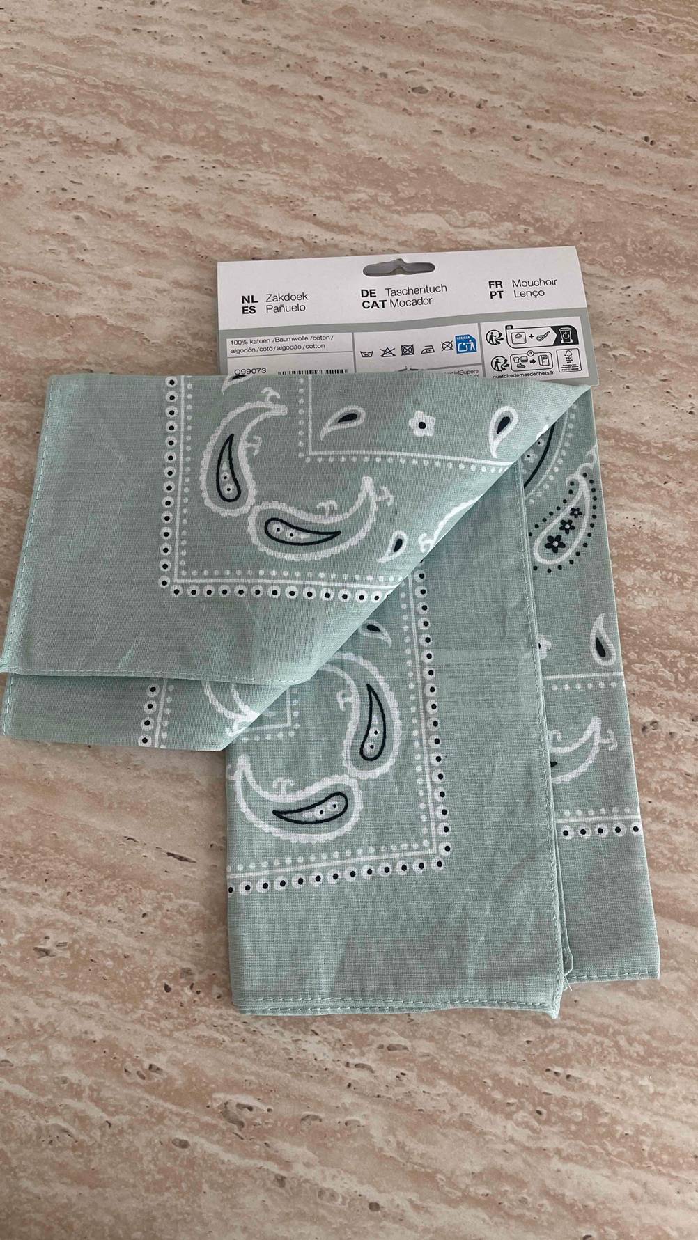 Die getesteten Bandanas in Grau liegen in einem Zweier-Pack auf einer marmorierten Oberfläche.