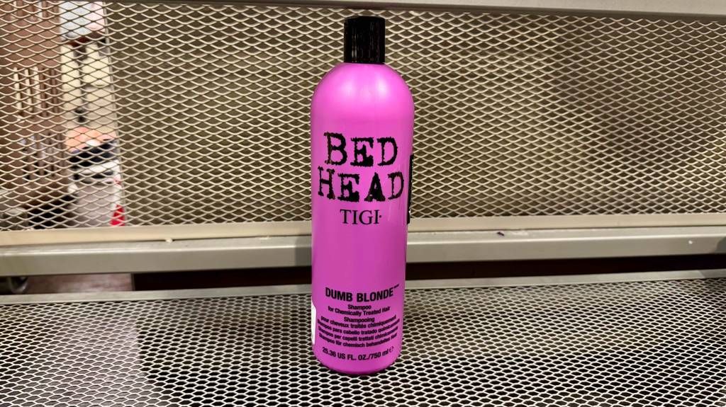 Das getestete Bed-Head-Shampoo in der pinken Quetschflasche steht auf einem Regal im Verkaufsbereich.