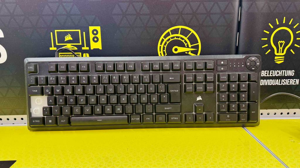 Im Test: Die schwarze Corsair-Tastatur im Test befindet sich auf einem gelben Ausstellungsregal.
