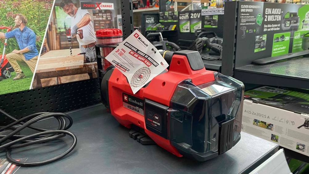 Rote Einhell-Gartenpumpe im Test steht in einer Verkaufszone.