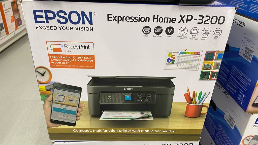Drucker unter 100 Euro im Test: Eine Verpackung mit einem Expression Home EP-3200 von Epson steht in einem Verkaufsbereich.