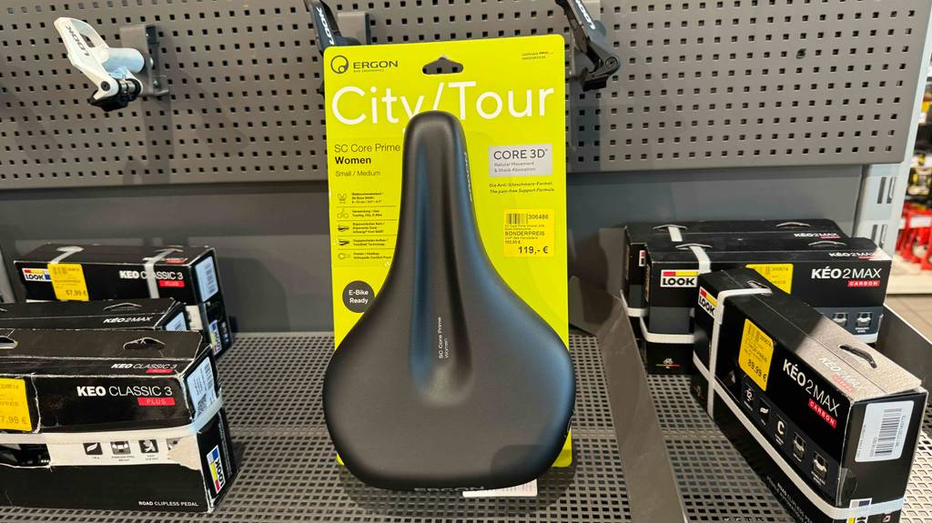 Auf einem Verkaufsregal befindet sich ein Ergon Sattel im Test neben weiterem Fahrrad-Zubehör.