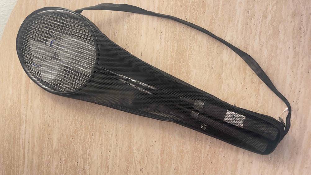 Federball-Sets Test: Eine schwarze PVC- und Stofftragetasche inklusive Sichtfenster liegt auf einer beigefarbenen Oberfläche.