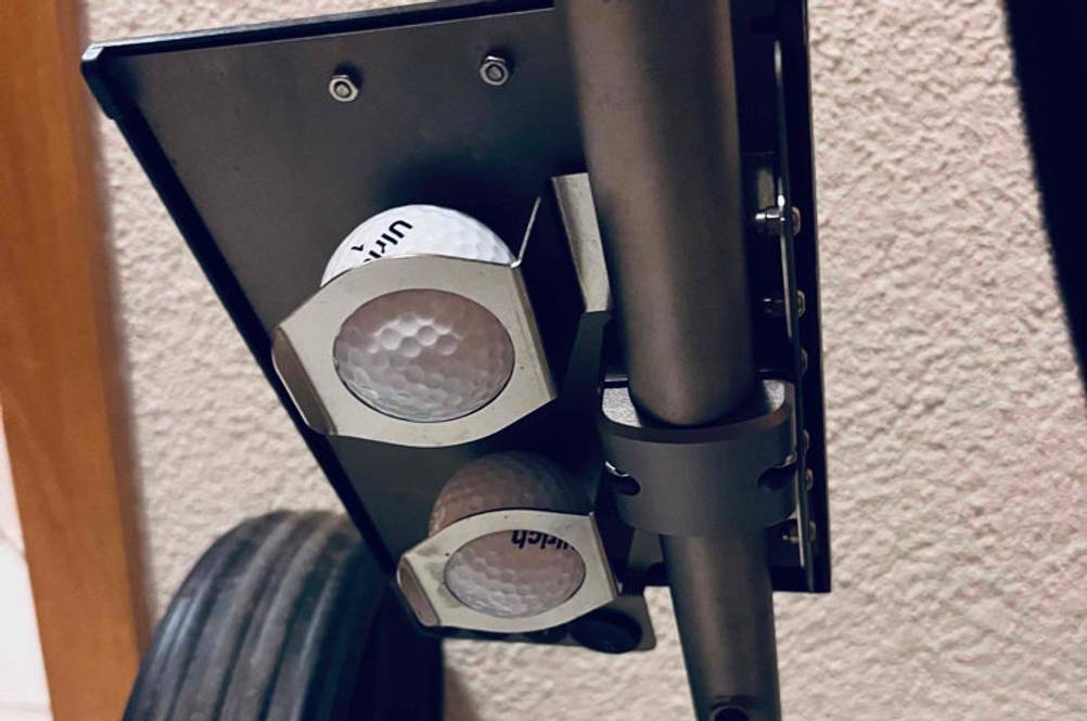 Golf-Trolley im Test: Detailansicht der Golfball-Halterung oberhalb des Rads eines Golftrolleys.