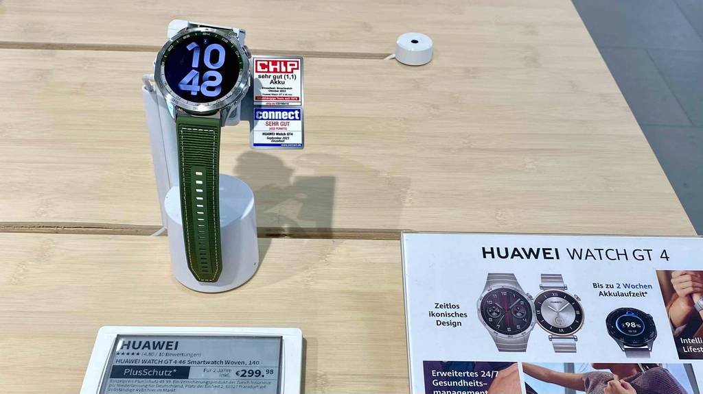 Huawei-Smartwatch im Test: GT 4 Modell mit rundem Bildschirm inklusive Metallrahmen und grünem Armband befindet sich in einem Ausstellungsbereich inklusive Preisschild.