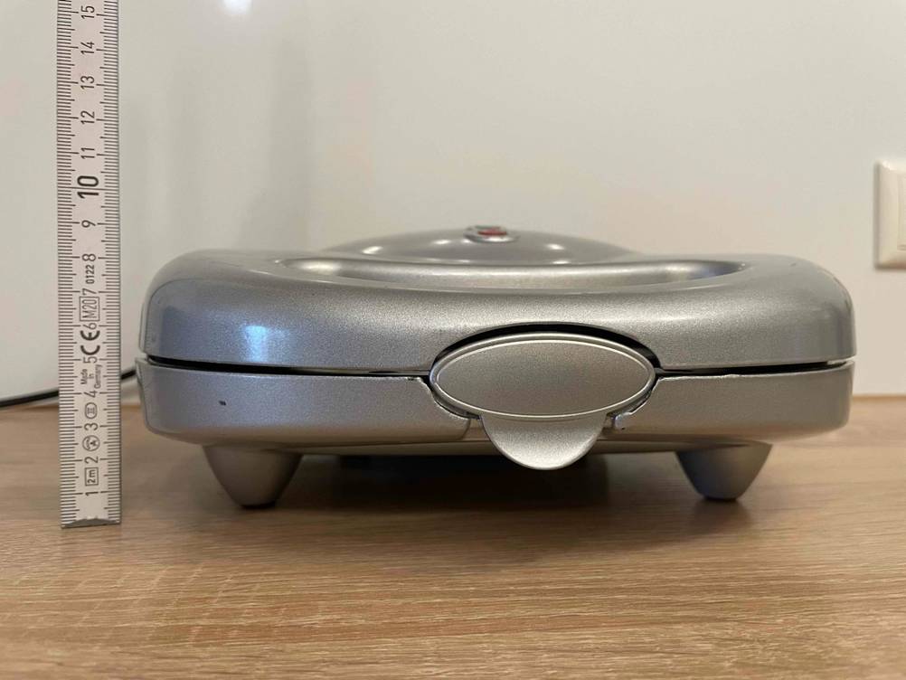 Ein Sandwichmaker 3 in 1 im Test steht neben einem Zollstock auf einem Tisch.
