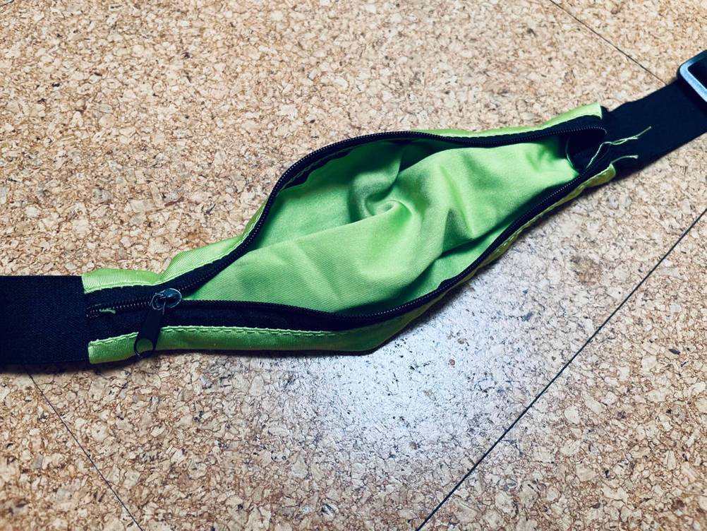 Laufgürtel-Test: Detailansicht eines mit Reißverschluss geöffneten, grünen Fachs.