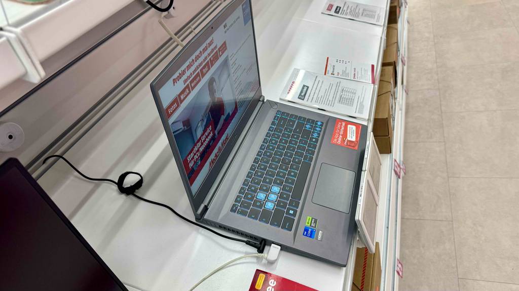 Ein MSI-Gaming-Laptop im Test steht von seitlich oben betrachtet mit geöffnetem Bildschirm auf einem Ausstellungsregal.