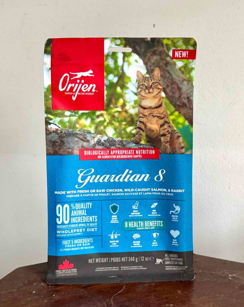 Das getestete Katzen-Trockenfutter von Orijen befindet sich in einer wiederverschließbaren 340-g-Frischhaltetüte auf einem Holztisch.