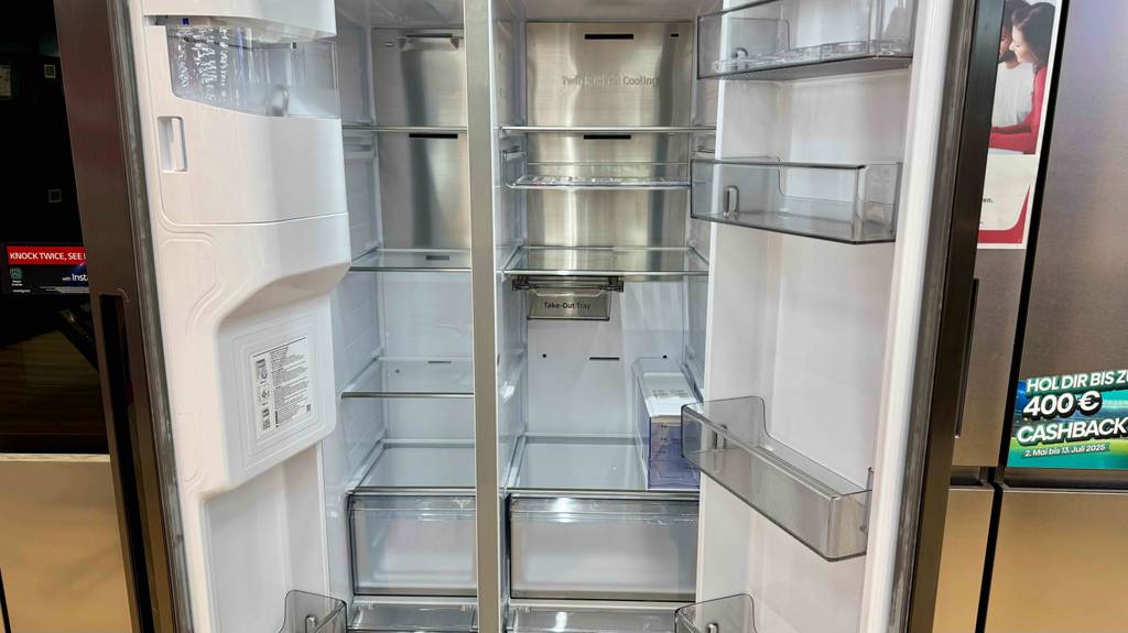 Der zweitürige Kühlschrank Samsung-Side-by-Side im Test steht geöffnet in einem Geschäft.