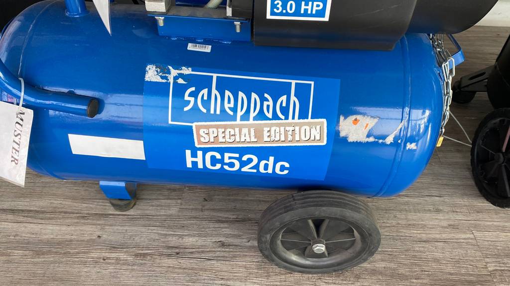 Scheppach-Kompressor-50l-Test: Ansicht des auf schwarzen Rädern stehenden, blauen Druckluftbehälters mit dem Logo von Scheppach.