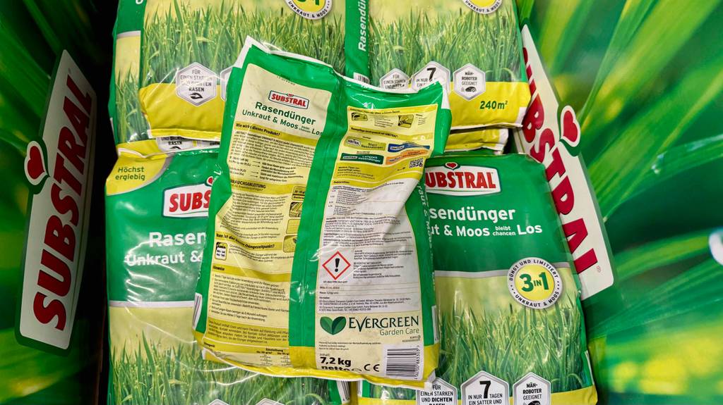 Im Test: Der Substral-Rasendünger in der 7,2-kg-Kunststofftüte, mit Fokus auf die Produktinformationen, liegt auf mehreren Verpackungen mit Rasendünger.