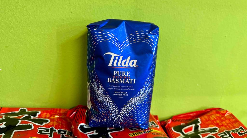 Tilda-Reis im Test vor einer grellgrünen Wand, die die blaue Packung hervorhebt.
