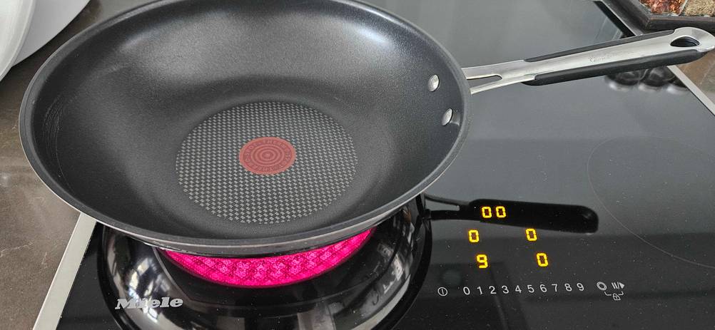 Wokpfannen-Test: ein Modell von Jamie Oliver steht auf einer eingeschalteten Induktionsplatte.