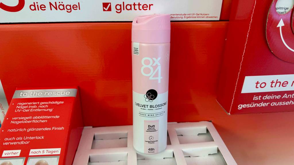 Ein getestetes 8x4-Deo-Spray steht auf einem Karton vor rotem Hintergrund.