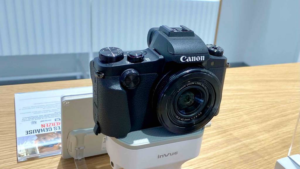Canon-Digitalkamera im Test steht inklusive Zoom-Objektiv ausgestellt in einem Verkaufsbereich.