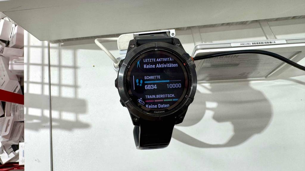 Eine schwarze Garmin-Uhr im Test befindet sich mit eingeschalteter Anzeige auf einem Ausstellungspodest im Verkauf.