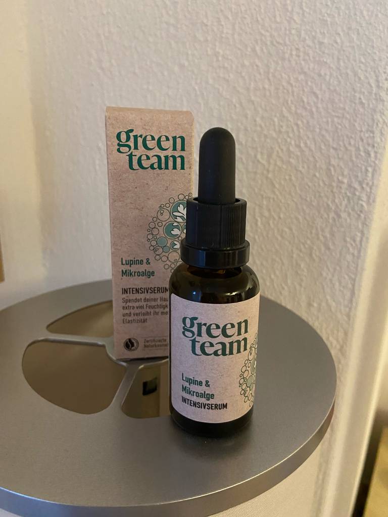 Auf einem Tisch steht eine Packung neben der braunen Flasche mit der getesteten Glättungscreme.