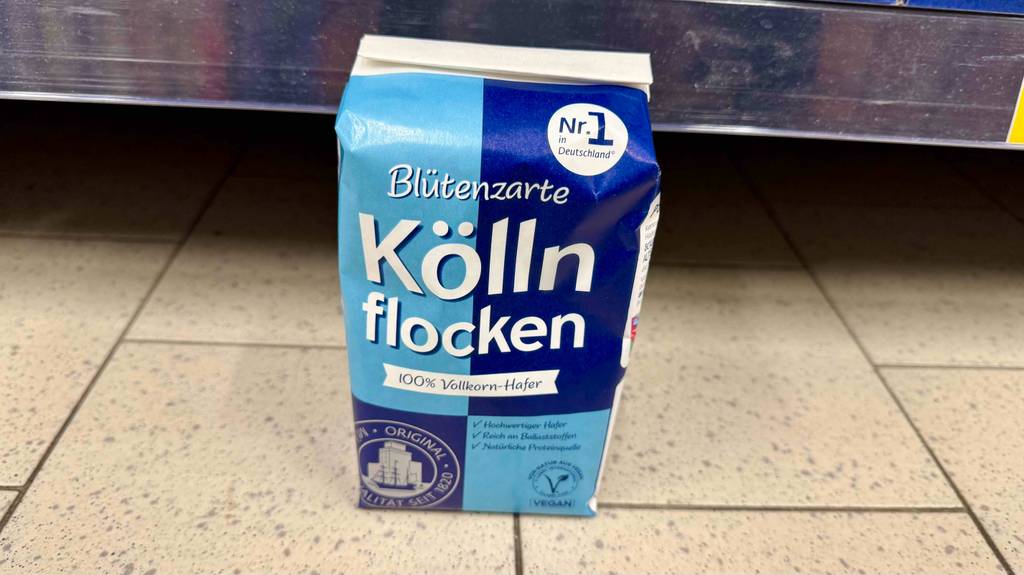 Eine Packung mit getesteten Kölln-Haferflocken steht vor einem Regal im Supermarkt.