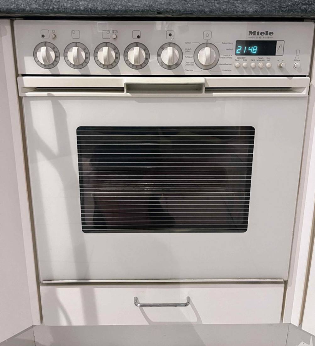 Backofen-Test: Gesamtansicht von einem weißen Einbau-Backofen von Miele in eine Küchenzeile integriert.