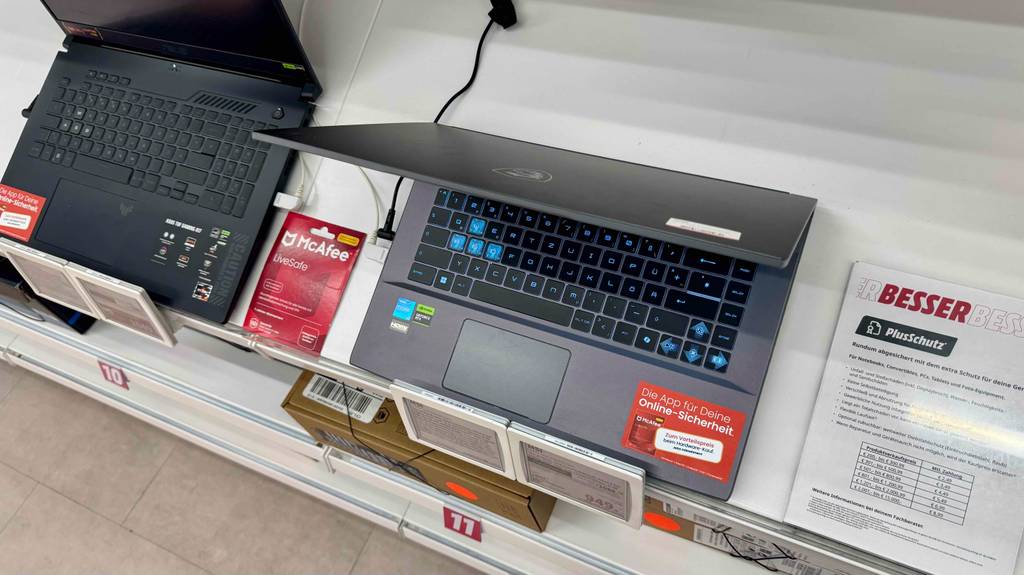 Ansicht von oben auf einen eingeschalteten MSI-Gaming-Laptop im Test, der neben anderen Laptops steht.