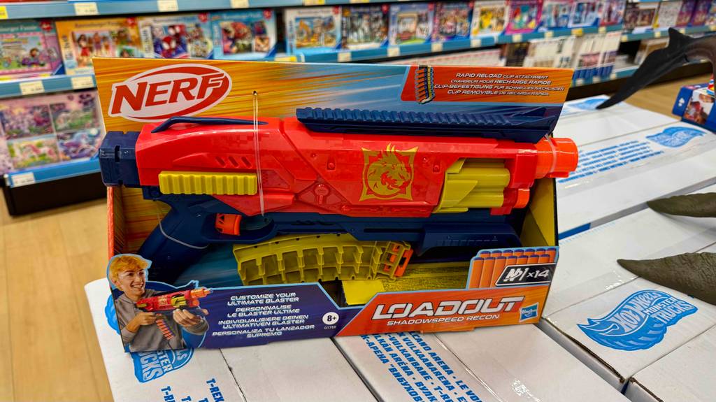 Die getestete Nerf-Gun in Rot befindet sich in ihrer Verpackung auf mehreren weißen Kartons im Spielwarenladen.