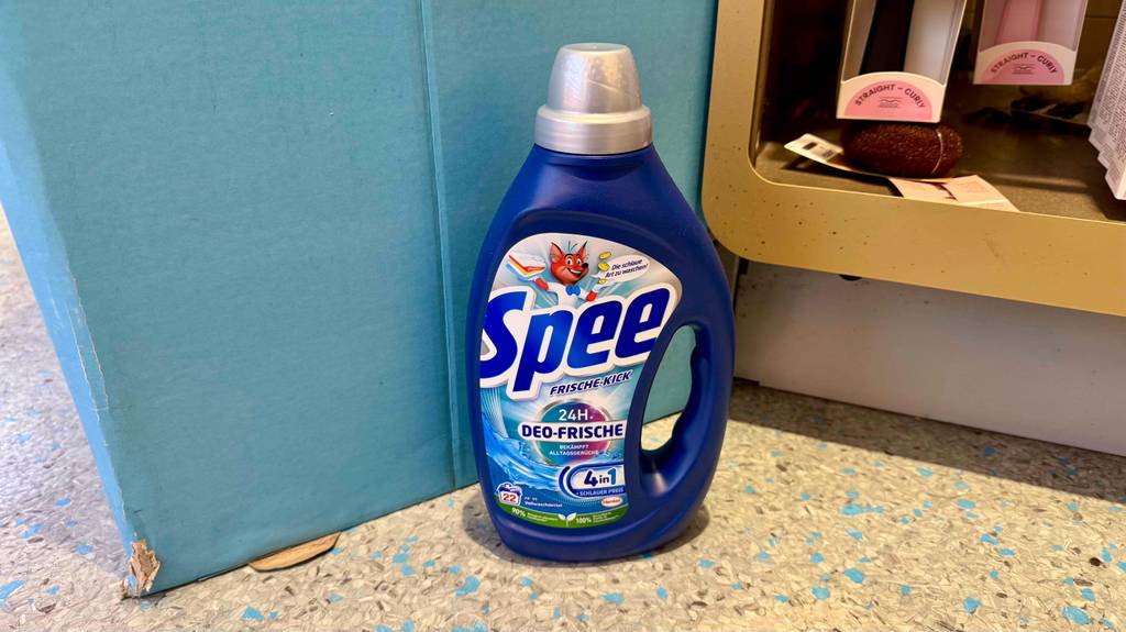 Getestet: Spee-Waschmittel in der Flasche steht auf dem Boden vor einem Regal.