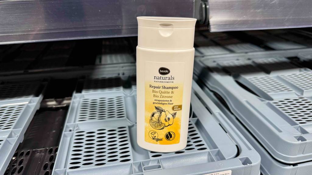 Eine Kunststoffflasche mit getestetem veganem Shampoo von Bevola steht auf einem Kunststoffkorb.