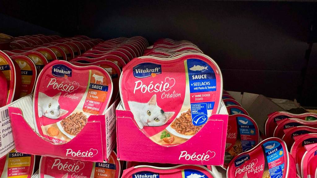 Mehrere Schalen mit getestetem Vitakraft-Katzenfutter stehen im Karton auf einem Regal im Verkaufsbereich.