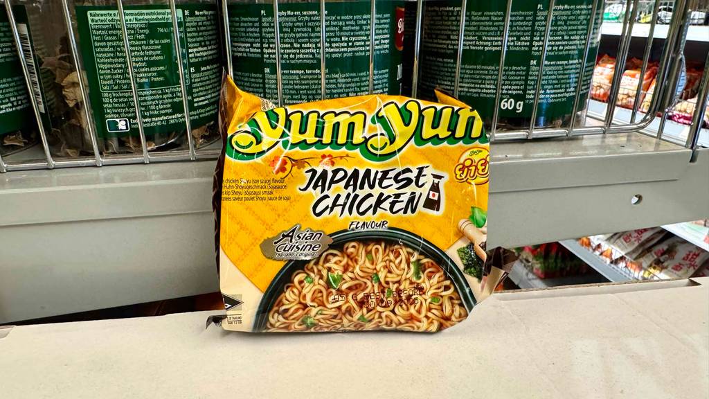 Im Test: Yum-Yum-Nudeln aus der Tüte liegen vor einem Verkaufsregal mit Nudelpackungen.