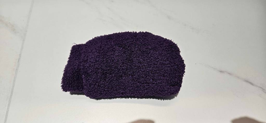 Wintersocken-Test: zusammengerollte lilafarbene Frottee-Socken liegen auf einer weißen Oberfläche.