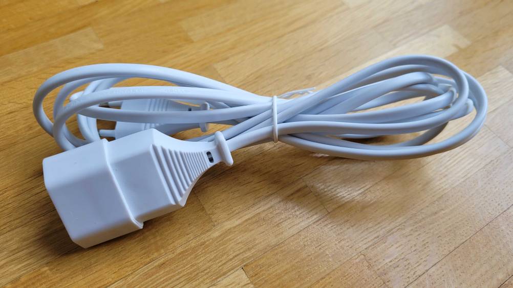 Verlängerungskabel getestet: Ein Kabel zusammengebunden horizontal auf einem Holzboden.