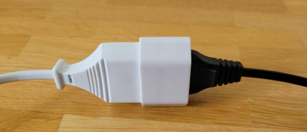Ein weißes Verlängerungskabel mit einem angeschlossenen, schwarzen Kabel.
