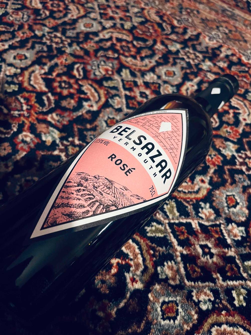 Auf dem Teppich liegt eine Flasche getesteter Rose-Vermouth.