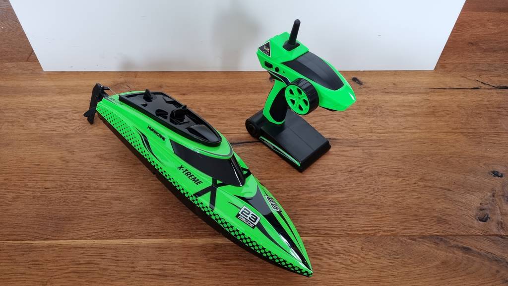 Ferngesteuertes Boot und Fernbedienung stehen auf dem Boden