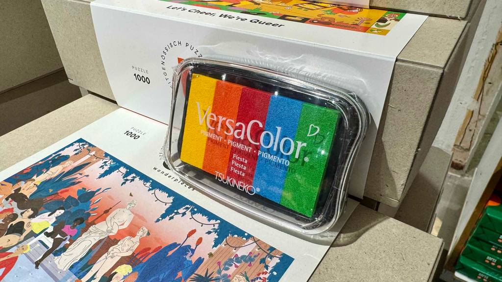 Das getestete Stempelkissen inklusive fünf verschiedener Farben lehnt an einer Puzzle-Verpackung.