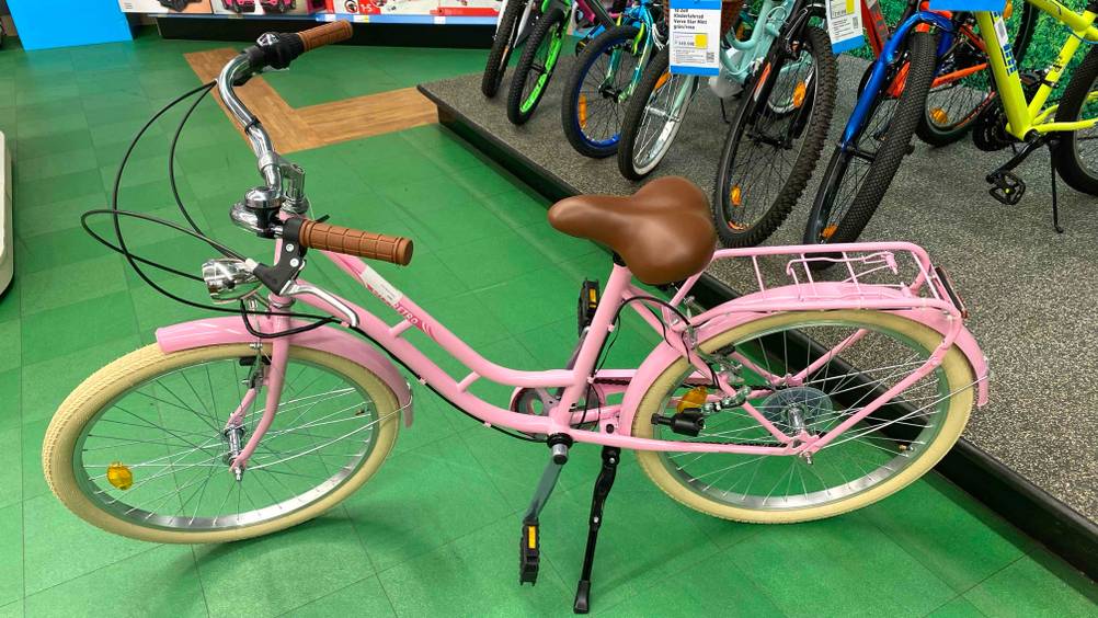 Ein getestetes Kinderfahrrad 24 Zoll in einem Verkaufsraum von der Seite im Hintergrund andere Räder.