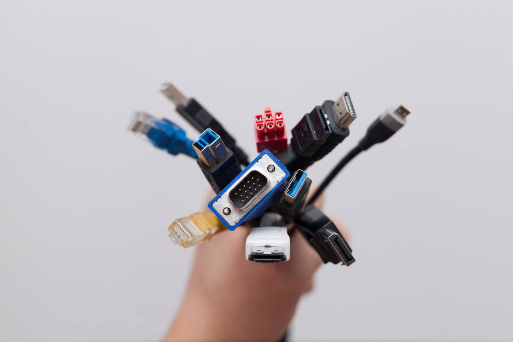 VGA-HDMI-Adapter im Test: Ein Bündel mit Kabeln, darunter Phonet, VGA, HDMI, Ethernet in einer Hand.