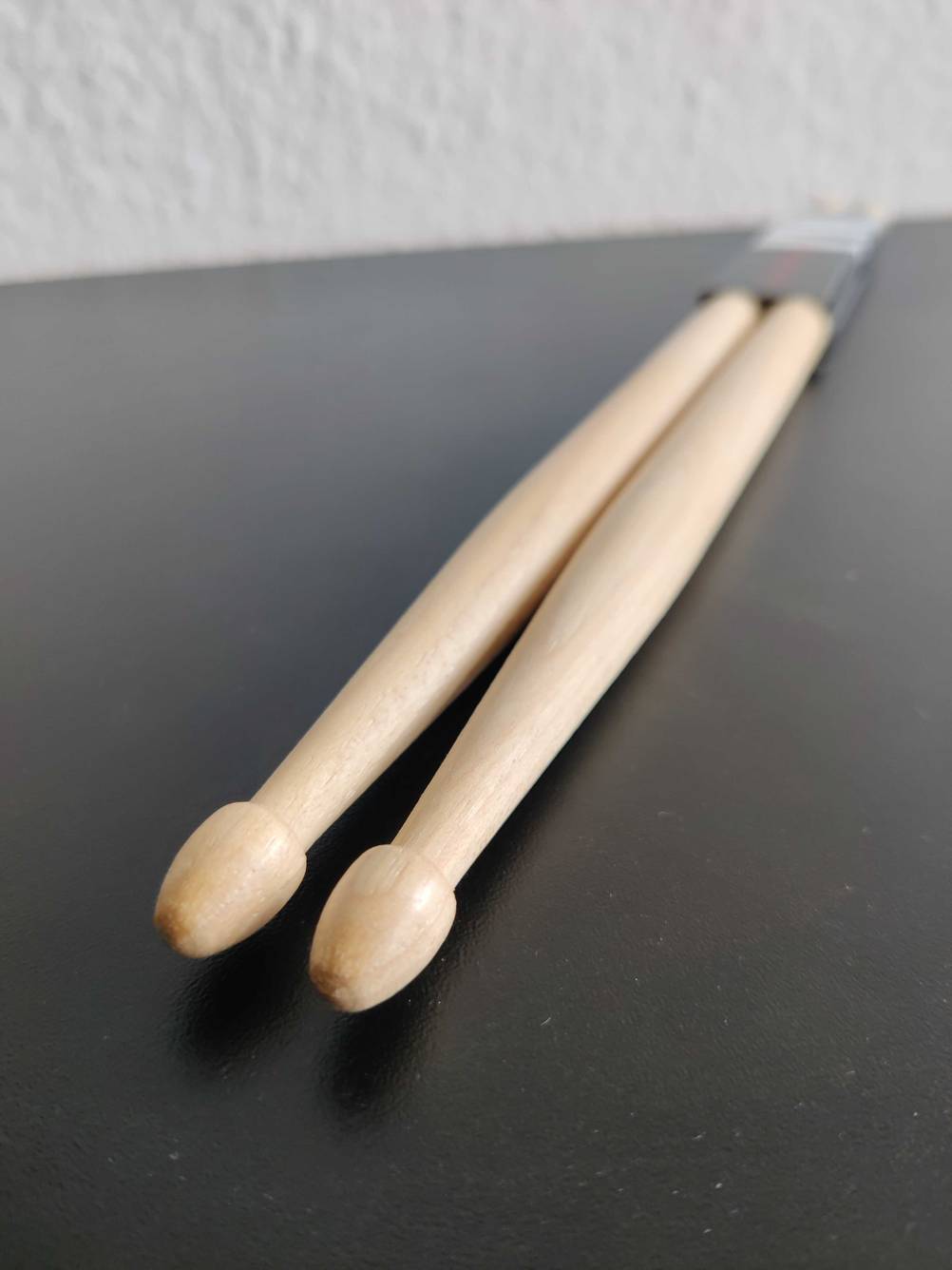Nahaufnahme der Kugeln vorne an den getesteten Drumsticks auf einer dunklen Fläche.