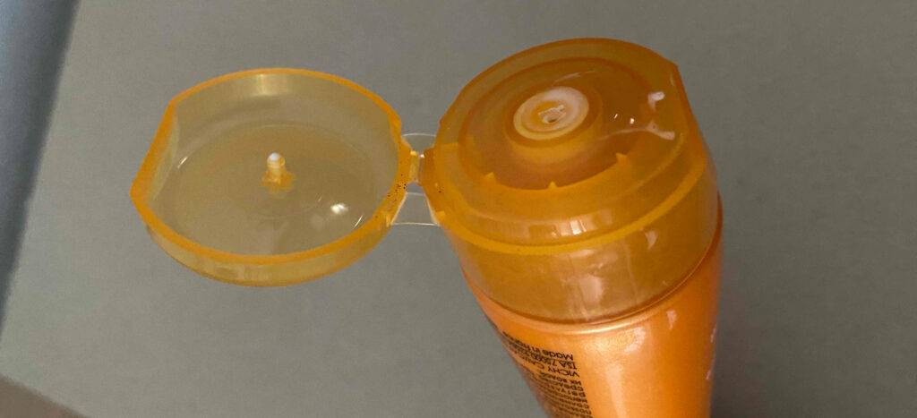 Nahaufnahme der Quetschöffnung einer orangefarbenen Tube, die die getesteteTagescreme mit LSF 30 der Marke Vichy enthält.