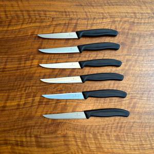 Sechs Victorinox-Swiss-Classic-Steakmesser liegen übereinander auf einem Tisch