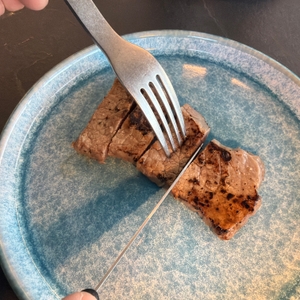 Ein Steak wird mit dem Victorinox-Swiss-Classic-Steakmesser geschnitten