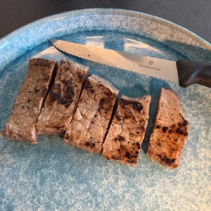 Ein geschnittenes Steak liegt neben dem Victorinox-Swiss-Classic-Steakmesser