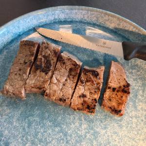 Ein geschnittenes Steak liegt neben dem Victorinox-Swiss-Classic-Steakmesser