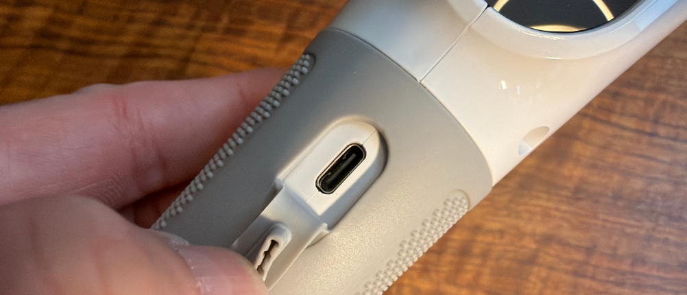 Eine Hand öffnet den Ladeanschluss der elektrischen Vikeri-Reinigungsbürste