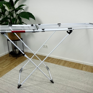 Der Vileda Doble ist komplett aufgeklappt und steht auf einem hellen Teppich. Die seitlichen Trockenflächen sind vollständig ausgezogen.