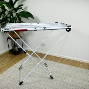 Der Vileda Doble steht vollständig zusammengeklappt im Raum. Die Leinen sind kompakt ineinandergelegt, die Füße sind gekreuzt.