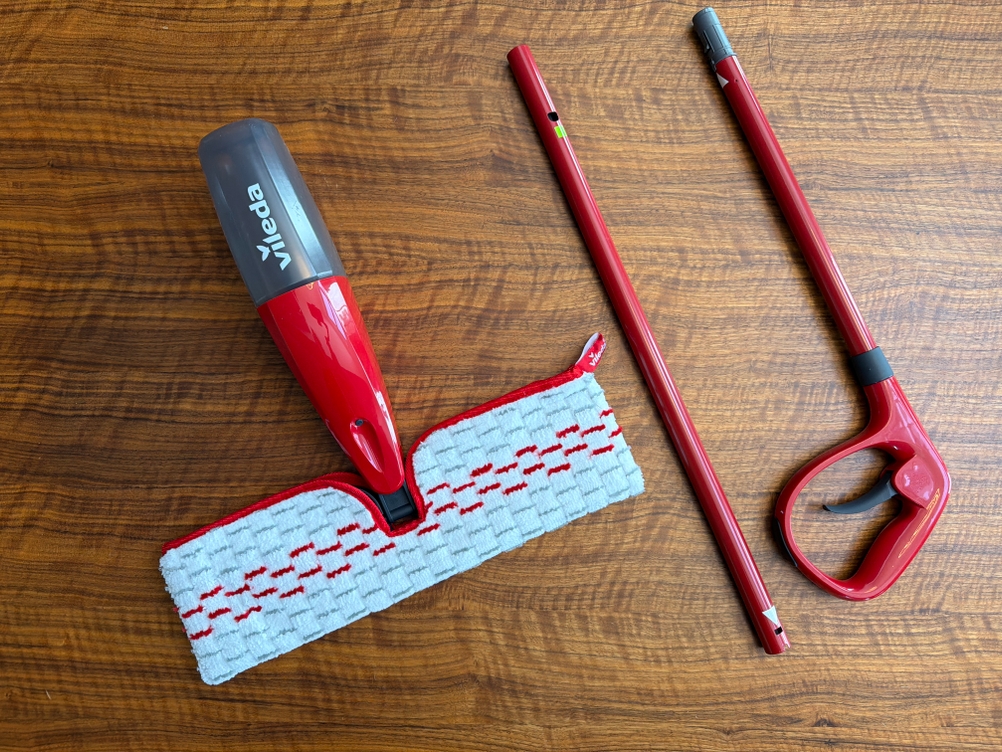 Der Vileda Spray & Clean liegt auseinandergebaut auf einem Tisch.